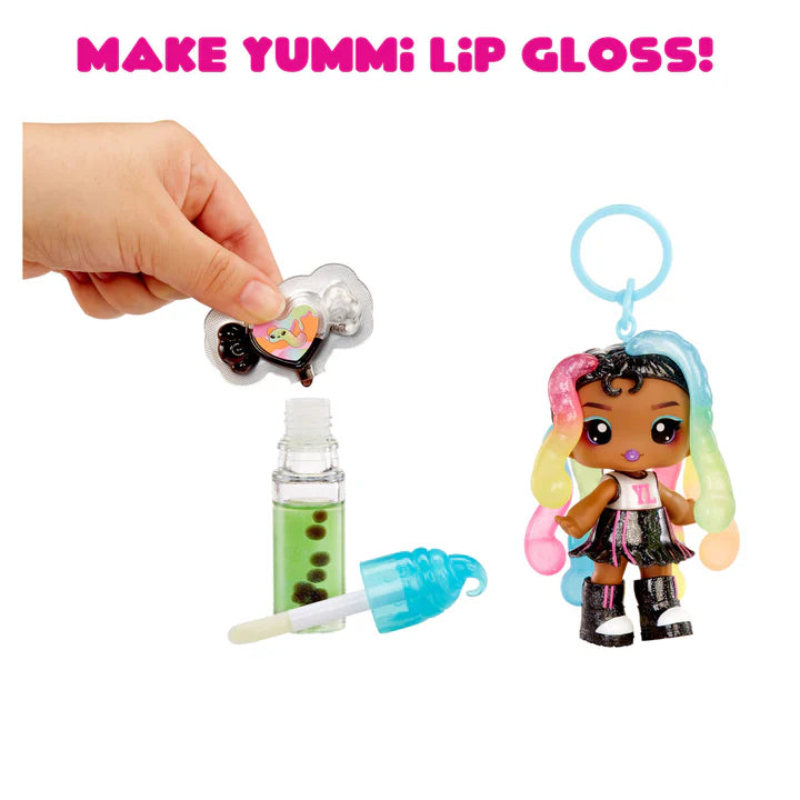 Make Yummi lip gloss set with a small doll and lip gloss applicator on a white background.