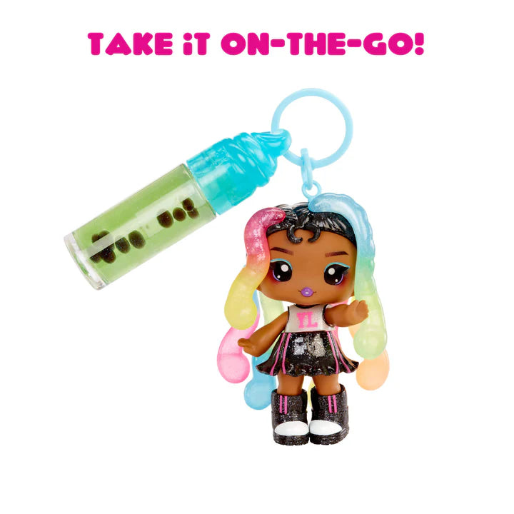 Toy figure with colorful hair and a bottle-shaped keychain on a white background with text 'TAKE IT ON-THE-GO!'.