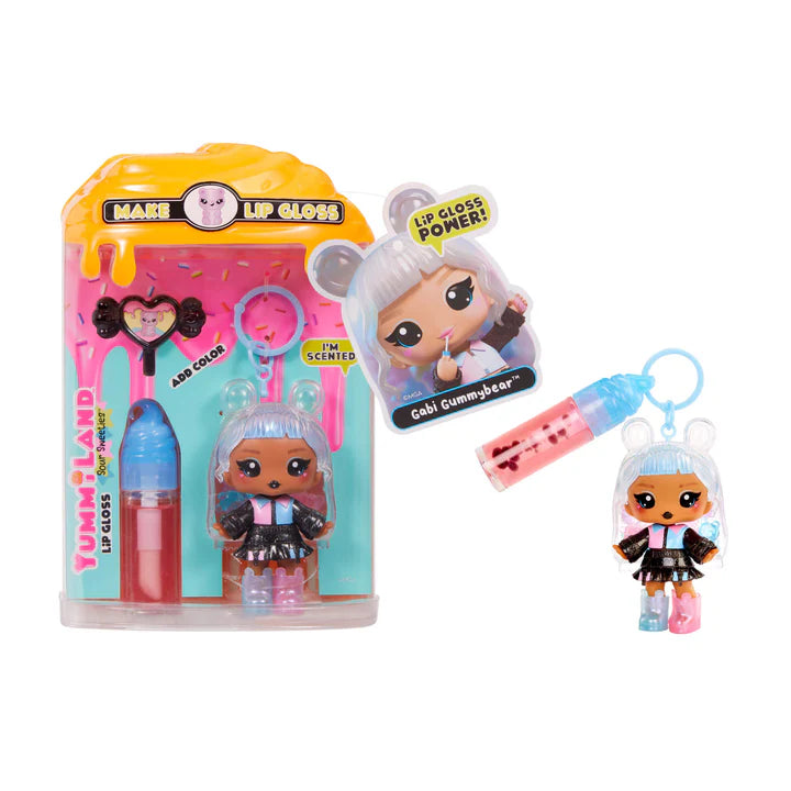 Yummiland Sour Sweeties Gabi Gummybear doll with clear hair featuring gummy bears, a pink and blue top, plaid skirt, and mismatched boots, shown with DIY lava lamp lip gloss kit components including pink lip gloss tube, scented drop packet, and keychain ring.