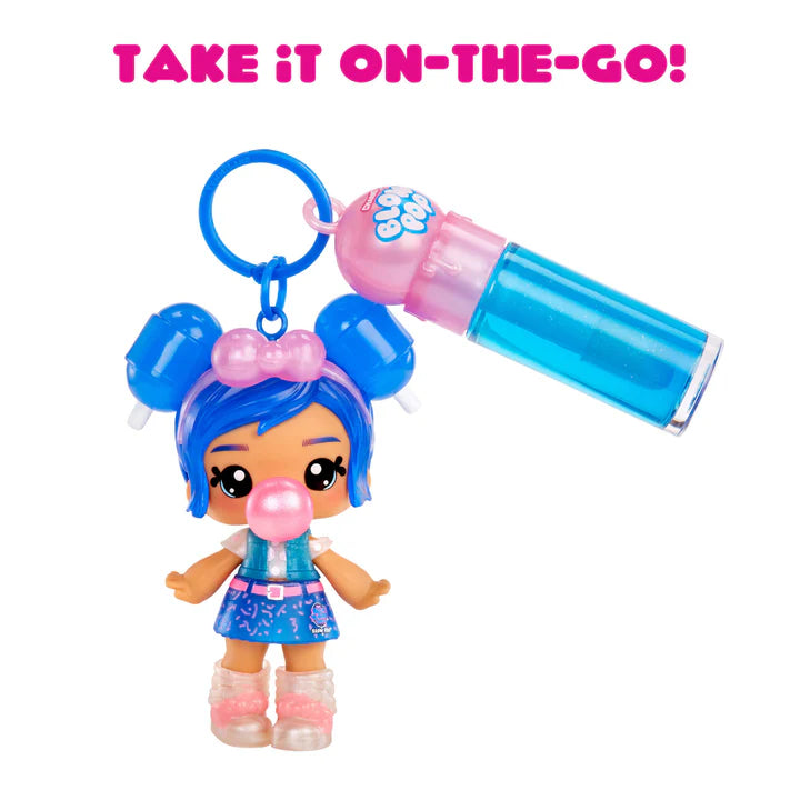 Yummiland x Blow Pop Blue Raspberry lip gloss doll with blue hair in buns, blowing a pink bubblegum bubble, wearing a blue outfit, shown with DIY lip gloss kit components including blue lip gloss tube, scented liquid packet, stirring spoon, and keychain ring.