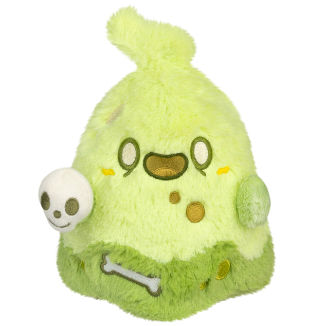 Green plush toy with cartoon face on a white background