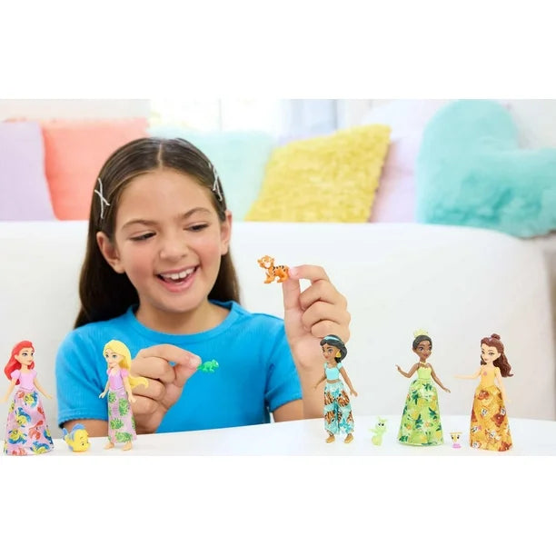 Girl playing with miniature dolls on a colorful couch