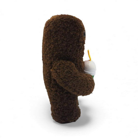 Side view of the 6.5-inch Domo plush, a brown fuzzy rectangular monster with a large open mouth holding a green boba tea cup.
