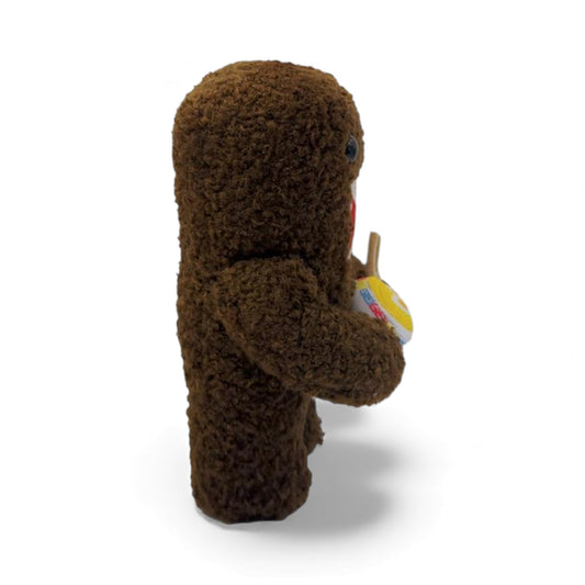 Side view of the 6.5-inch Domo plush, a brown fuzzy monster with an open
mouth holding a bowl of ramen noodles with chopsticks.