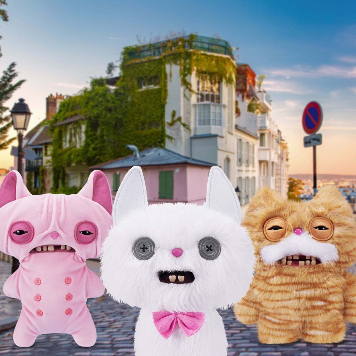Three Fuggler Alley Cat plush toys in a city street setting with buildings and a sunset.