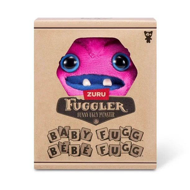 Display box of A small, bright pink Fuggler Baby Fugg plush toy (Greedy Grinner) with large blue eyes, two white baby teeth showing in a blue mouth, and a spiky purple tuft of hair on top.