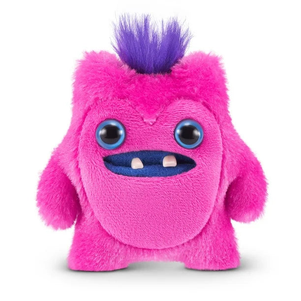 A small, bright pink Fuggler Baby Fugg plush toy (Greedy Grinner) with large blue eyes, two white baby teeth showing in a blue mouth, and a spiky purple tuft of hair on top.