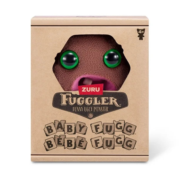 Display box of A small, roundish brown Fuggler Baby Fugg plush toy (Hedge Grog) with large green eyes, two white baby teeth showing in a pink mouth, and a spiky brown tuft of hair on top.