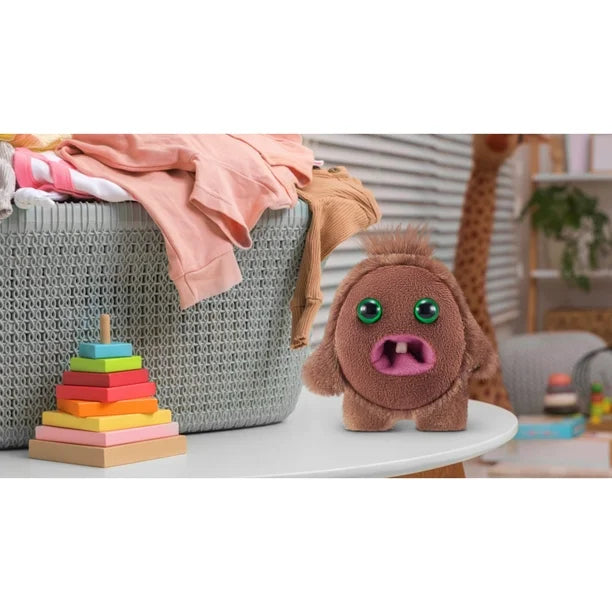 Plush toy resembling a cartoon character on a table with colorful stacking blocks and a basket in the background.