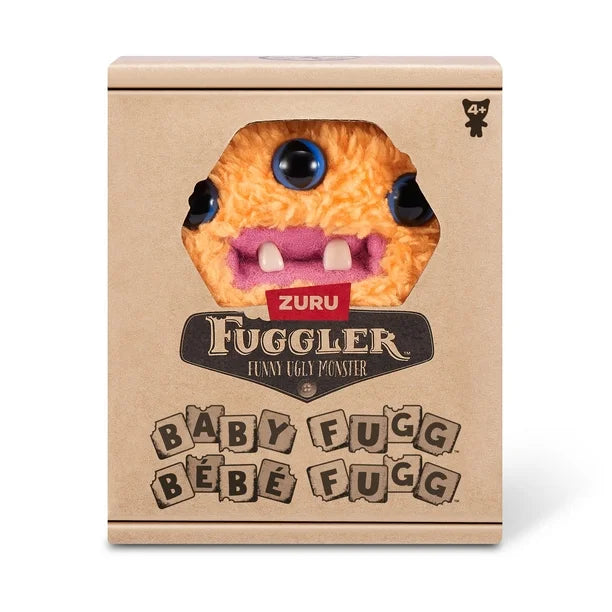 Display box of A small, shaggy orange Fuggler Baby Fugg plush toy (Reek-O) with three blue eyes across its face, three white baby teeth showing in a pink mouth, and a spiky purple tuft of hair on top.
