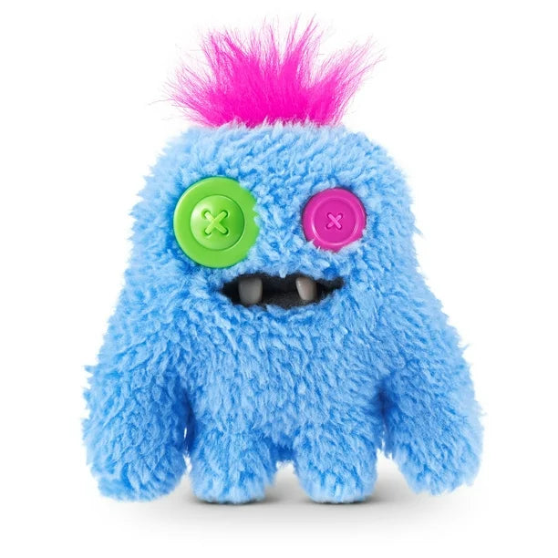 A small, shaggy blue Fuggler Baby Fugg plush toy (SaBQuoosh) with mismatched button eyes (one green, one pink), two white baby teeth showing, and a spiky pink tuft of hair on top.