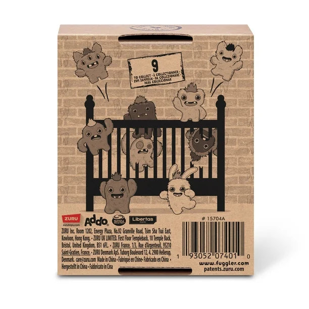 Back of display box for A small, yellowish-beige Fuggler Baby Fugg plush toy (Screech) with large green eyes, one white baby tooth showing in a pink mouth, and a spiky brown tuft of hair on top.