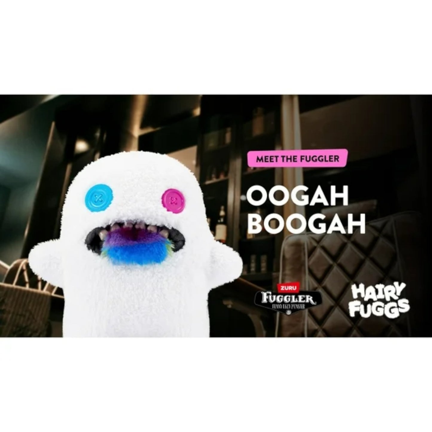 Oogah Boogah Fuggler plush by ZURU with hairy tongue and teeth with colorful eyes and mouth, labeled 'Oogah Boogah', in a blurred indoor setting.