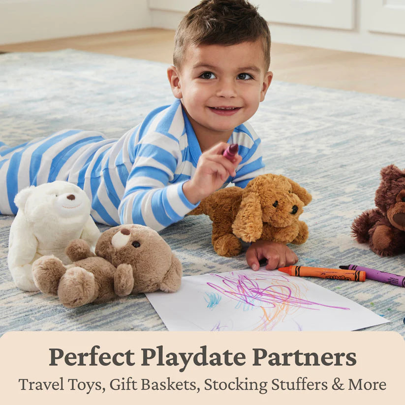 child coloring on floor surrounded by gund plush