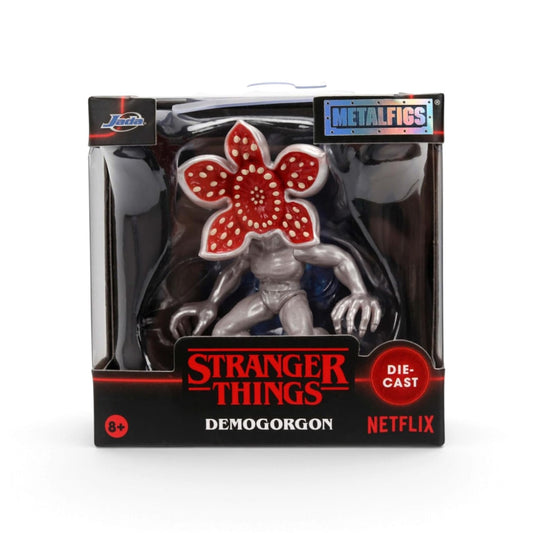 Stranger Things Demogorgon die-cast metal figure in its original window box packaging, featuring a metallic silver body and a red flower-like head with white dots, with branding for Metalfigs, Stranger Things, and Netflix.
