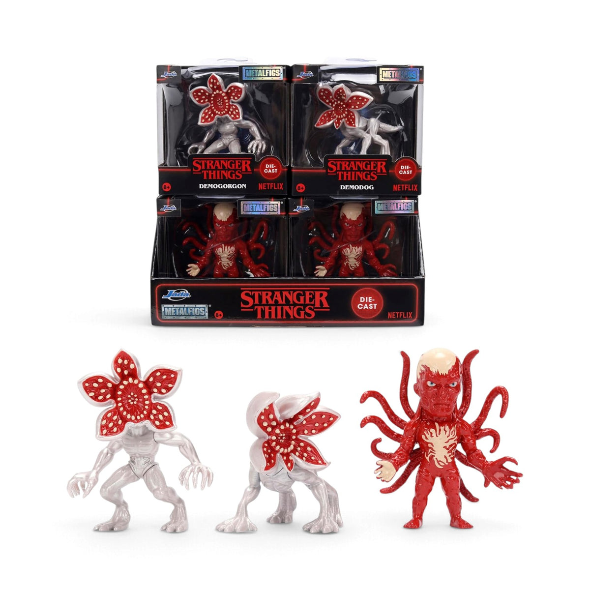 Stranger Things Metalfigs figure display set featuring three red and white Demogorgon figures, with four packaged figures displayed in a black retail counter box on a white background.