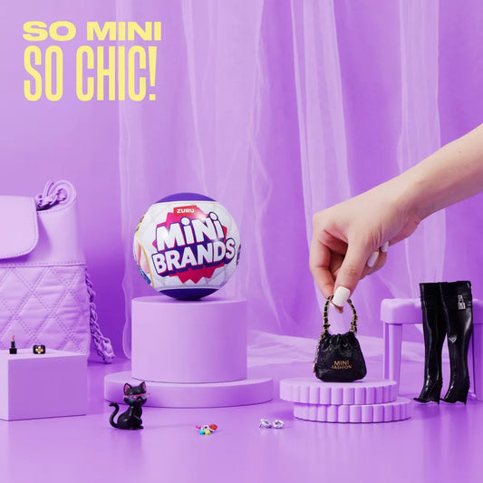 Miniature handbag on a purple stand with 'Mini Brands' branding, against a purple curtain background.