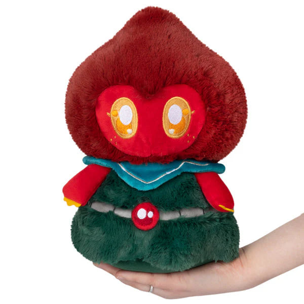 Squishable Mini Flatwoods Monster Plush toy with a red and green design held in a hand on a white background