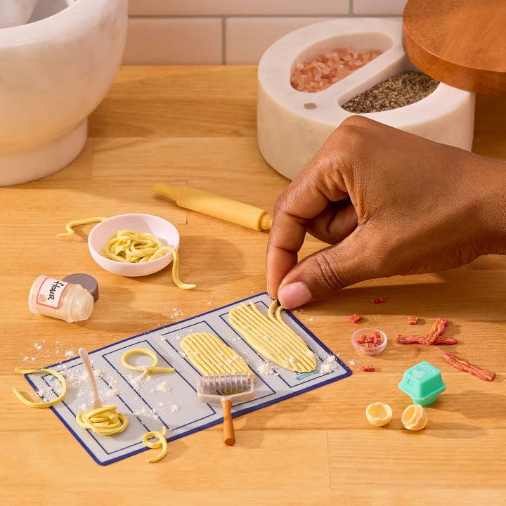 Person making pasta with a manual pasta maker on a wooden surface. Miniverse Make It Mini From Scratch Series 2