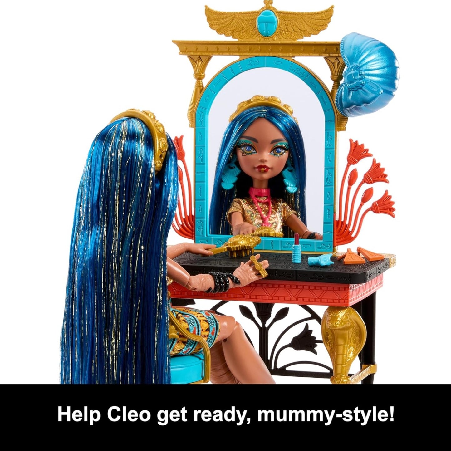 Toy doll with blue hair sitting at an Egyptian-themed vanity mirror and table.