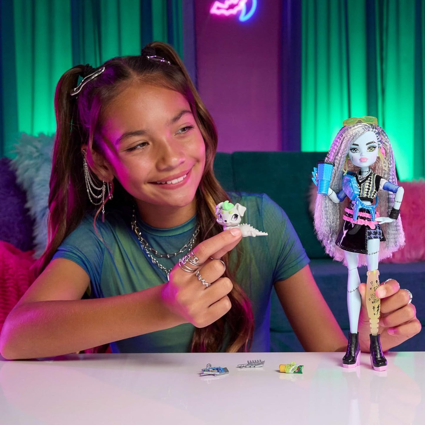 Girl holding a Monster High Frankie Stein Core Refresh doll with colorful background