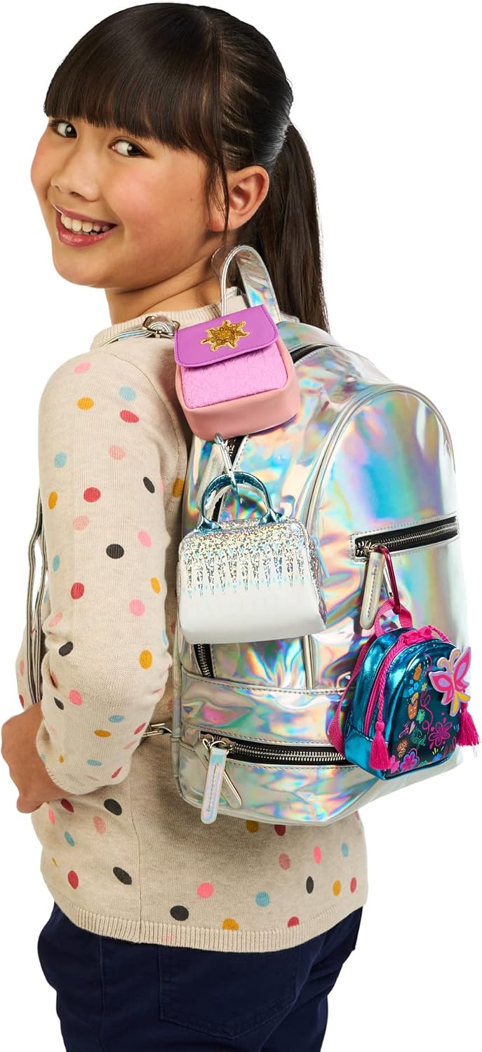 Girl wearing backpack with Six different styles of Real Littles Disney mini bags: Encanto butterfly backpack, Buzz Lightyear backpack, Rapunzel sun purse, Maleficent horned handbag, Tiana flower wallet, and Frozen glitter handbag