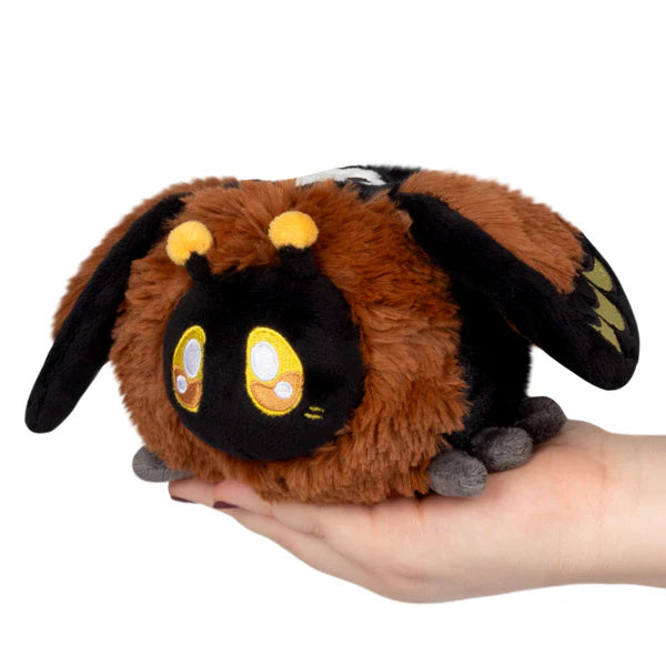 Squishable Snackers Death's-head Hawkmoth Plush toy resembling a dragon held in a hand on a white background