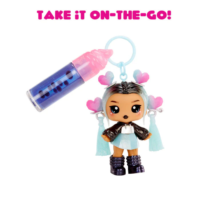 Keychain with a small doll figure and pink and blue cylindrical object on a white background.