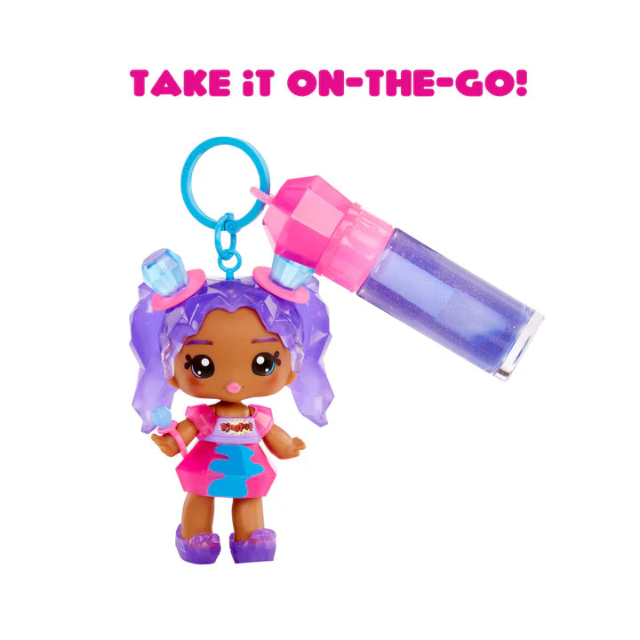 Small doll with purple hair and a pink and blue container on a white background with 'Take It On-The-Go!' text.