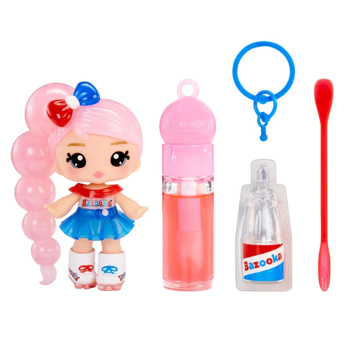 Yummiland x Bazooka Bubble Gum lip gloss doll with pink hair styled like bubbles, wearing a red, white, and blue outfit, shown with DIY lip gloss kit components including pink lip gloss tube, scented liquid packet, stirring spoon, and keychain ring.