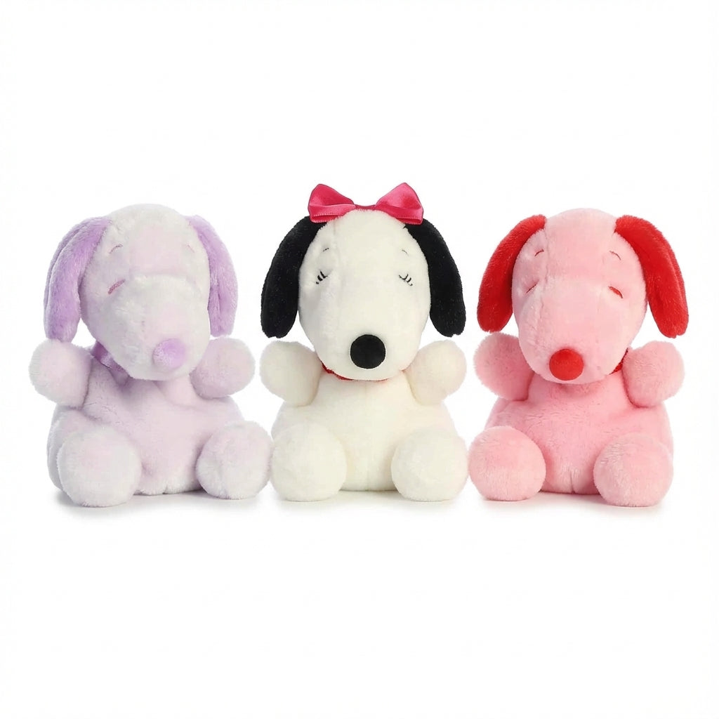 Palm Pals Peanuts: Purple Snoopy, Belle with pink bow, and Pink Snoopy plush. Available at ReChild.