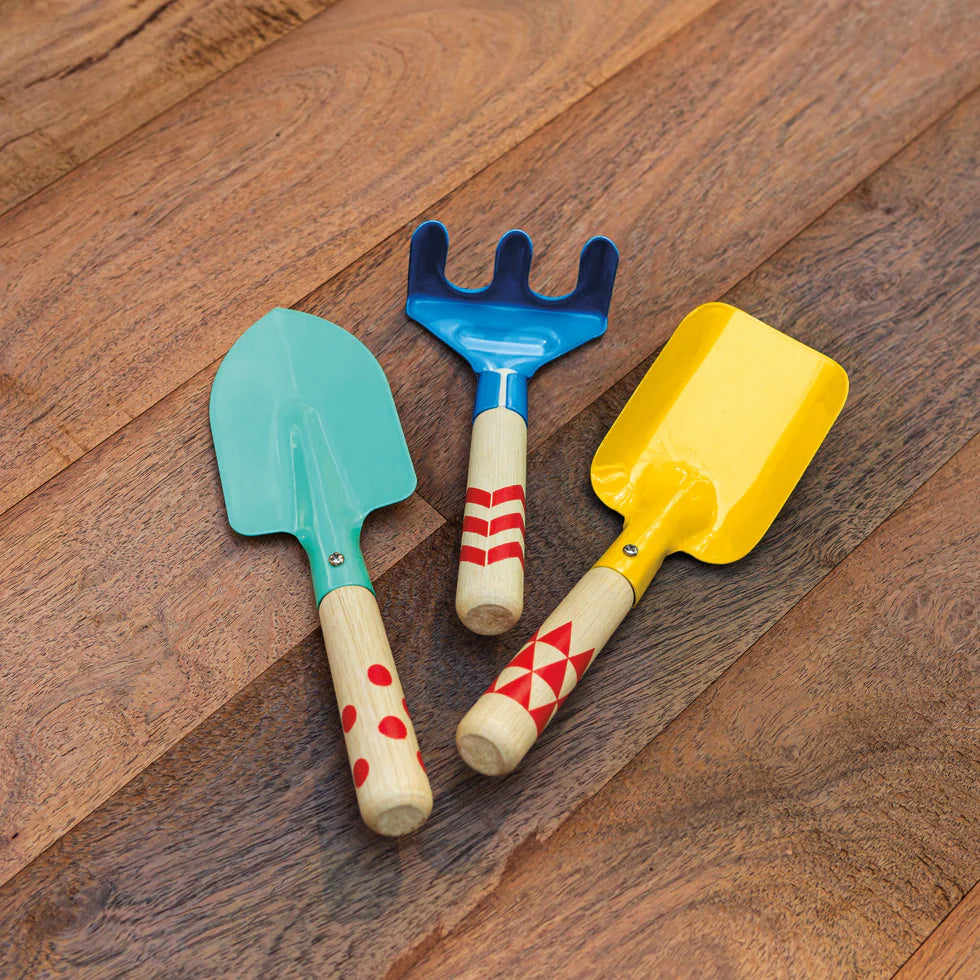 Three colorful children's gardening tools on a wooden surface