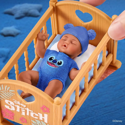 Toy baby doll in a crib with 'Stitch' design on a blue background