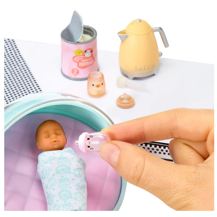 MGA's Miniverse Make It Mini Real Baby Series 1 surprise capsule with miniature baby doll, high chair, and crafted baby food.