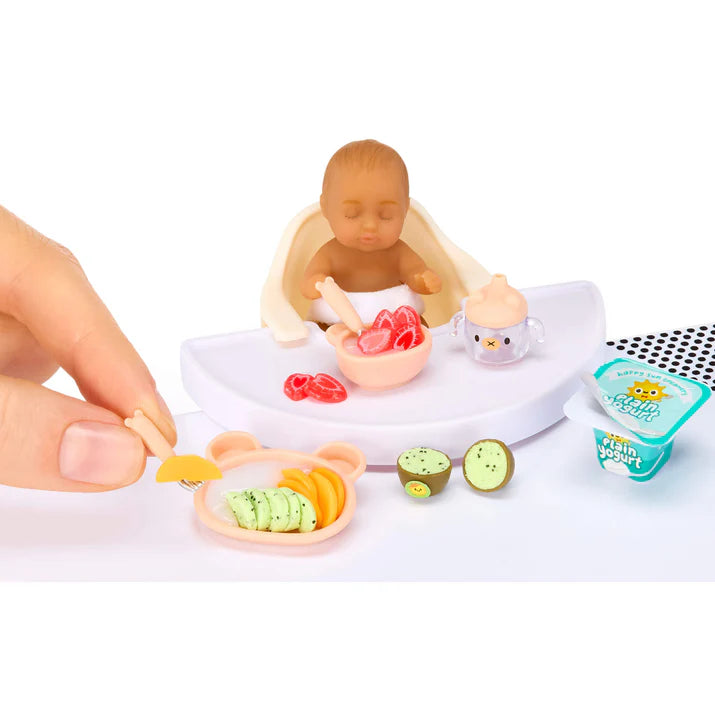 MGA's Miniverse Make It Mini Real Baby Series 1 surprise capsule with miniature baby doll, high chair, and crafted baby food.