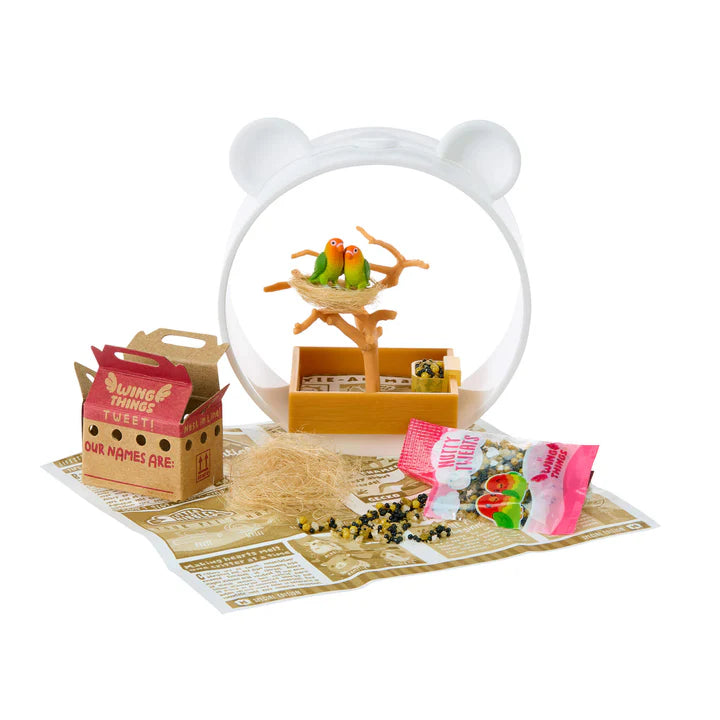 Miniature bird setup with a snow globe, birds in a nest, and accessories on a white background