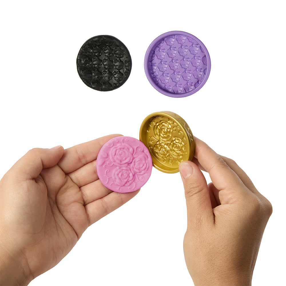 Hands holding decorative round objects in various colors on a white background
