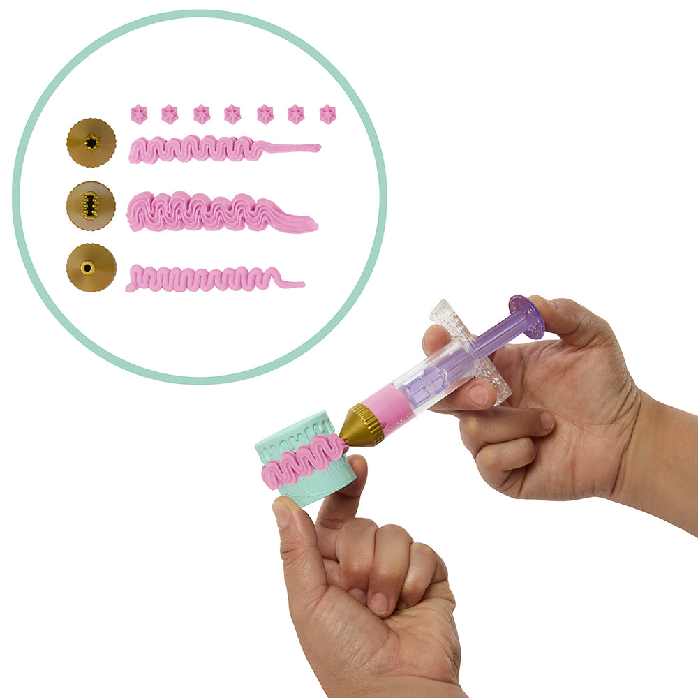 Hand holding a toy syringe with decorative elements and color swatches on a white background