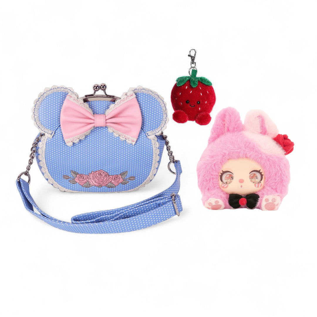 Blue bag with pink bow, strawberry keychain, and pink plush toy on a white background