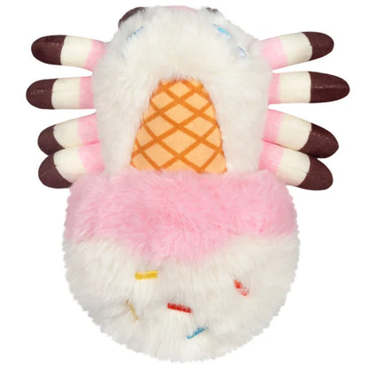 Squishable Alter Egos Series 20 Ice Cream Spider plush held in a hand, featuring fluffy white and pink fur, a waffle cone detail, and brown striped legs.
