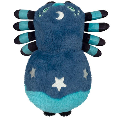 Squishable Alter Egos Series 20 Midnight Spider plush held in a hand, featuring deep blue fur, light blue striped legs, green eyes, and white moon and star details.