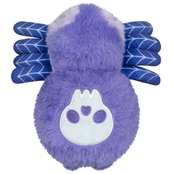 Squishable Alter Egos Series 20 Skull Spider plush held in a hand, featuring soft purple fur, pink eyes, blue web-patterned legs, and a skull printed on its back.