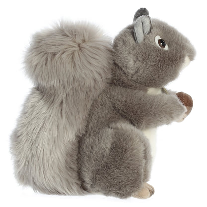 Aurora Miyoni Grey Squirrel lifelike plush stuffed animal sitting with an acorn, grey fur, and a bushy tail.