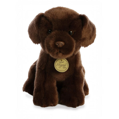 Aurora Miyoni Tots Chocolate Lab Pup lifelike baby plush stuffed animal sitting with soft chocolate-brown fur, floppy ears, and big expressive eyes.
