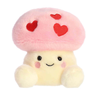 Product view of Aurora Palm Pals Brooklyn Mushroom, a small plush mushroom with a pink cap featuring three embroidered red hearts.