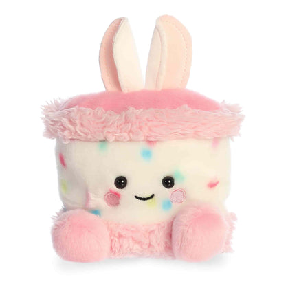 Product view of Aurora Palm Pals Bubbi Bunny Cake, a white confetti cake plush with pink frosting rims and bunny ears.