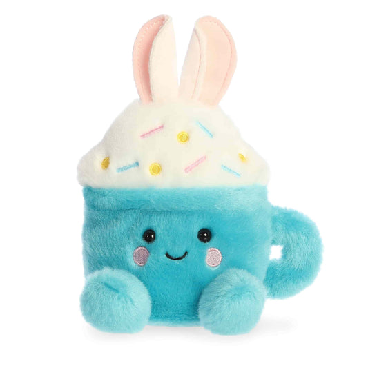 Product view of Aurora Palm Pals Lopi Bunny Latte, a blue plush mug with white foam, sprinkles, and bunny ears.