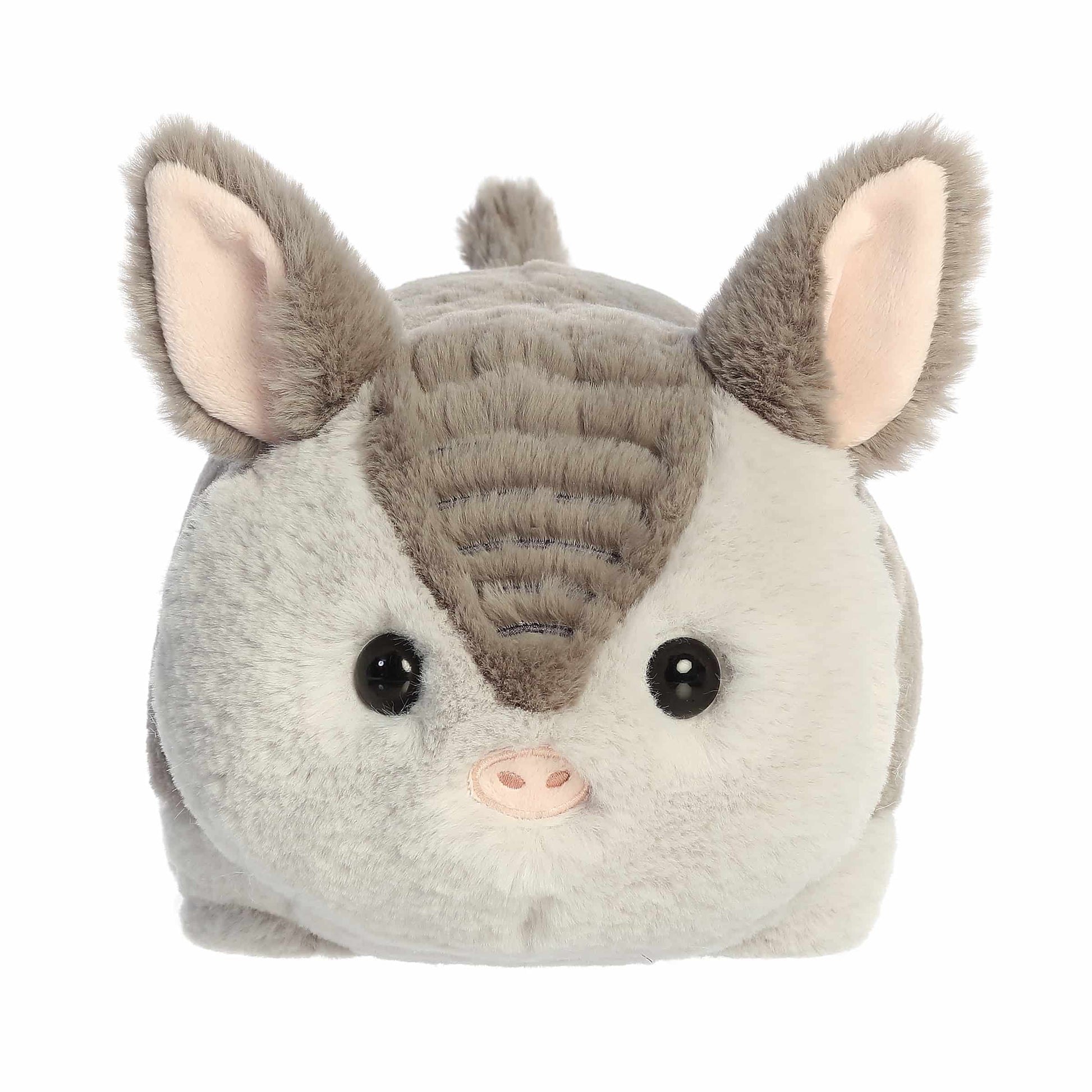 A product photo of the 10-inch Aurora Spudsters Arnie Armadillo, a grey and white, potato-shaped plush armadillo with a pink nose.
