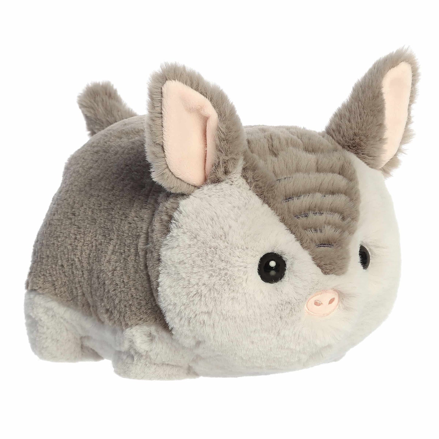 A product photo of the 10-inch Aurora Spudsters Arnie Armadillo, a grey and white, potato-shaped plush armadillo with a pink nose.