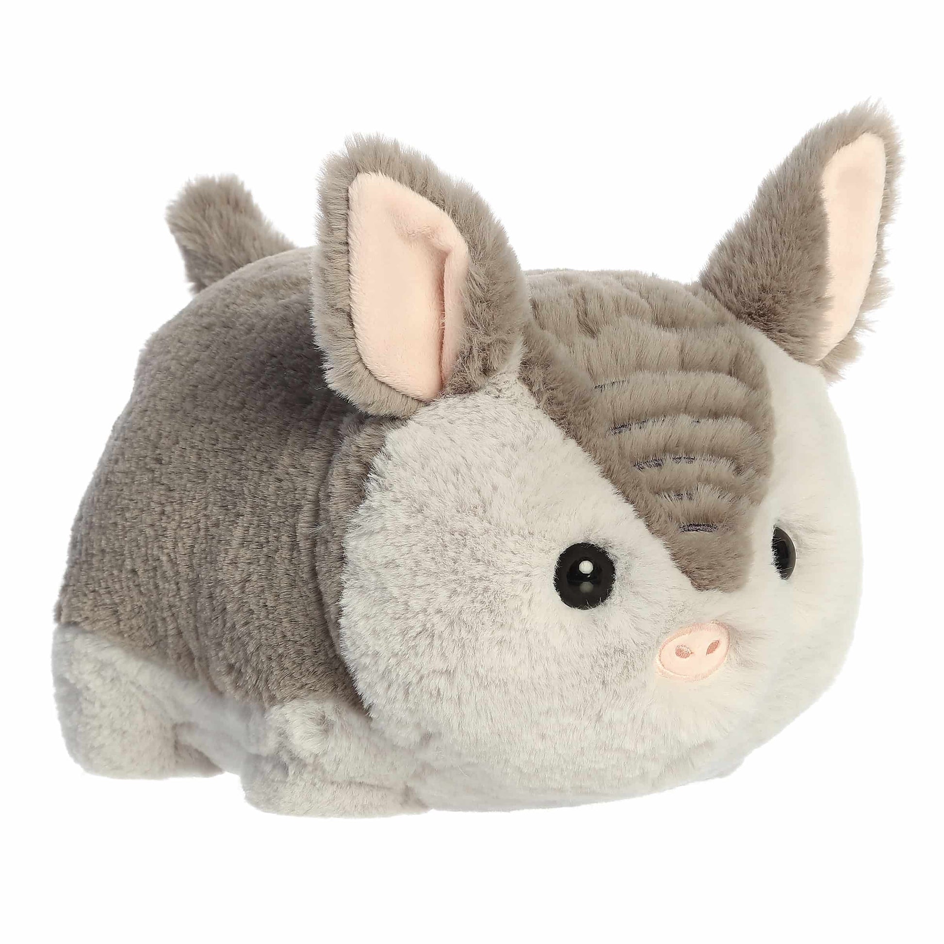 A product photo of the 10-inch Aurora Spudsters Arnie Armadillo, a grey and white, potato-shaped plush armadillo with a pink nose.